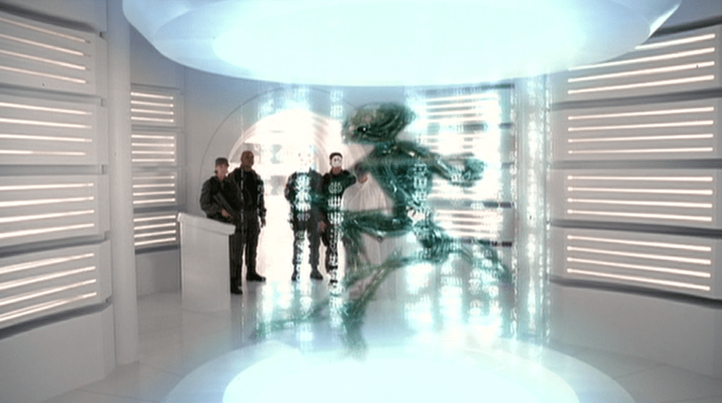 Das SG Team auf dem Schiff der Gadmeer, mit dem wunderschönen Shot, bei dem das Team aus Kameraperspektive hinter dem Hologramm eines Gadmeer steht.